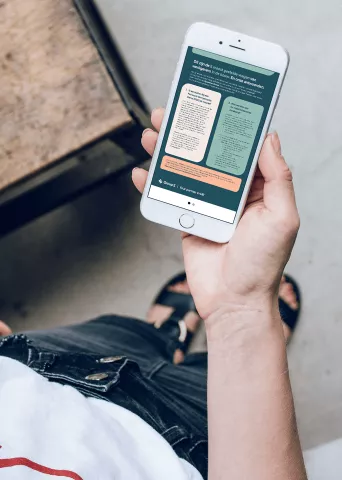 Hand holding a smartphone displaying the GroupS mobile app interface with informational cards on a green background.